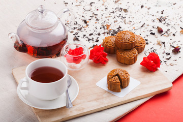 Chinese mid autumn festival foods. Traditional Chinese moon cakes on table setting with teacup.