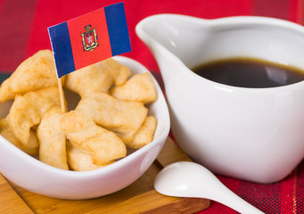 Delicious ecuadorian pristinos piled up in bowl, traditional andean pastry, cup of coffee siting on table, Quito flag planted inside pastries