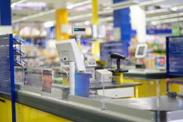 Close up of empty cash desk terminal with computer screen and card payment terminal in blue and yellow colour