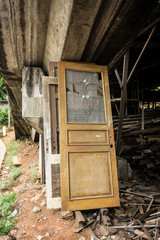 dismantled door made from wood and glass abandoned under the bridge photo taken in Jakarta Indonesia