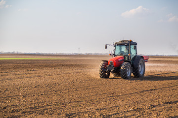 Farmer fertilizing arable land with nitrogen, phosphorus, potassium fertilizer