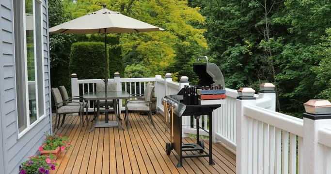 Cedar wood outdoor deck with BBQ cooker, beer and patio furniture with singing birds in background audio. 