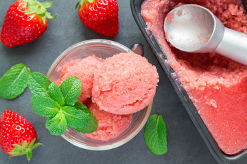 Homemade strawberry sorbet on a gray slate, top view