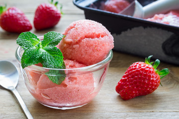 Homemade strawberry sorbet in glass on a wooden table