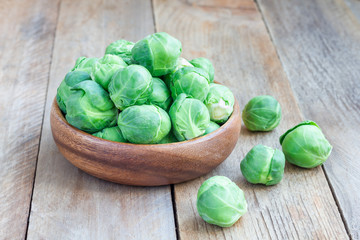 Brussels sprouts in a bowl on wooden background, horizontal