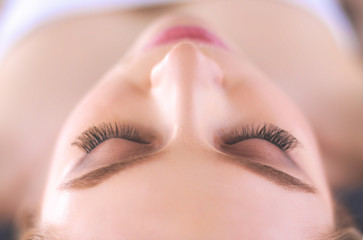 Obraz premium Młoda kobieta, leżąc na stole do masażu, relaksując się z zamkniętymi oczami