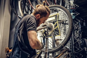 Fototapeta na wymiar Mechanic removing bicycle rear cassette in a workshop.