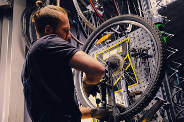 Mechanic removing bicycle rear cassette in a workshop.