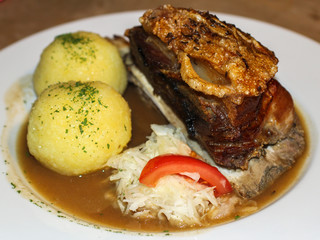 Half a grilled knuckle of pork with potato dumpling