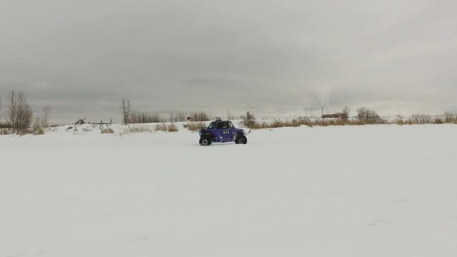 Winter racing side-by-side vehicles. Rally on the buggy on the snow on a winter day. Racing in the SXS class. Buggy, sports car on rally. Off Road Series racing. 4K video