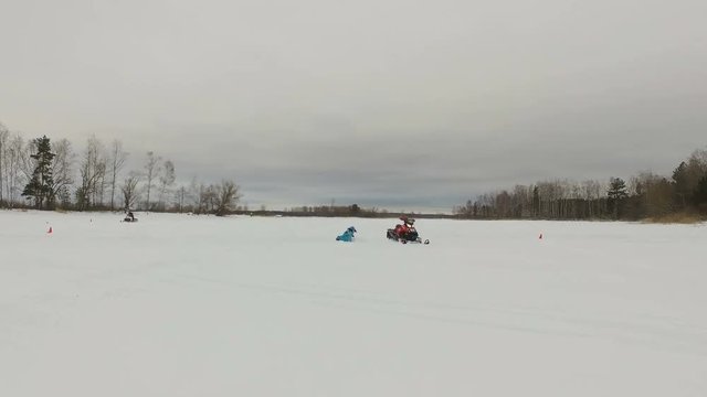 Man driving snowmobile in snowyfield. Snowmobile races. Man on a snowmobile. Winter sports and entertainment. 4K video