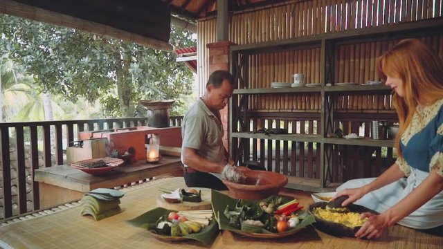 Cooking class in traditional balinese kitchen with brick oven, man walking