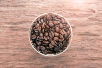 Top view of coffee. Coffee beans. Coffee cup full of coffee beans. Toned image.