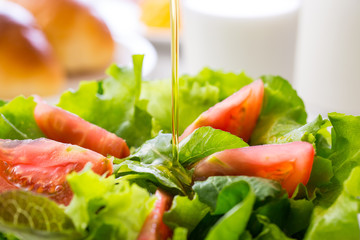 野菜サラダにドレッシングをかける