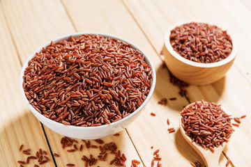 Rice berry in white bowl on wooden background