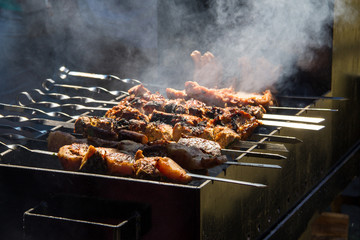 Grilled kebab cooking on metal skewer. Roasted meat cooked at barbecue.Traditional eastern dish, shish kebab. Grill on charcoal and flame, picnic, street food