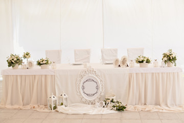Wedding ceremony decoration in the restaurant. Decoration of wedding table with tender white textile