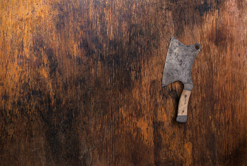 Vintage knife of butcher on old wooden background