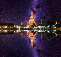 Wat Arun Buddhist religious places under milky way stars and space dust in the night sky, Bangkok,...