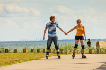 Young couple on roller skates riding outdoors