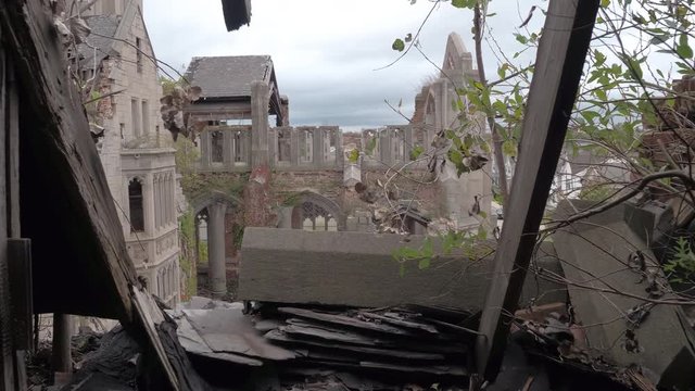 FPV, CLOSE UP: Standing on the roof looking at the crumbling sanctuary in abandoned City Methodist Church, Gary Indiana. Stunning burnt fortress falling apart. Abandoned cathedral disintegrating