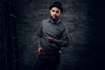 Bearded male dressed in a grey fleece shirt and a cylinder hat.