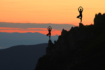 girl in a yoga pose on top of mountain