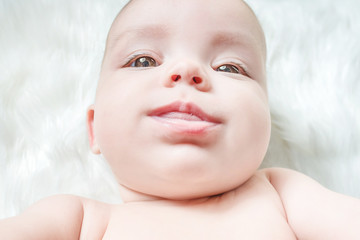 Cute baby lying on a white fur