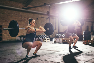 Fit people training lift barbells in gym