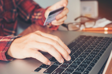 Man hand holding smartphone and credit card doing online banking.  shopping online