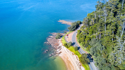 Obraz premium Aerial view on a road running along sea shore. Auckland, New Zealand.
