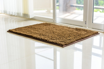 Brown cleaning door mat on the floor. - obrazy, fototapety, plakaty