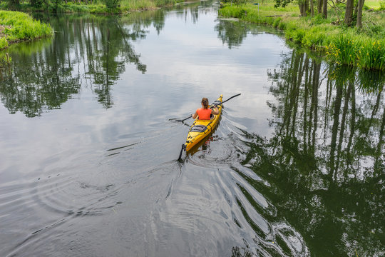 Girl kayaking on a river, beautiful nature landscape