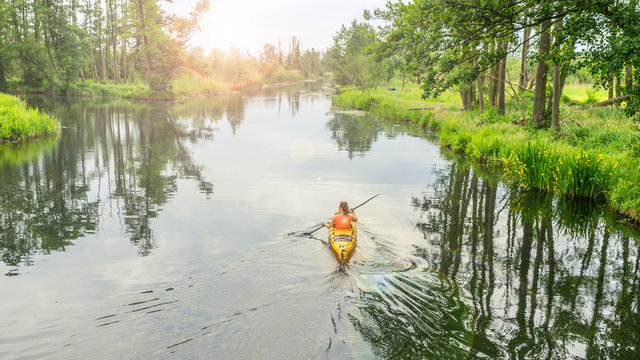 Girl kayaking on a river, beautiful nature landscape