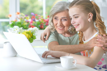 Girl with grandmother using tablet