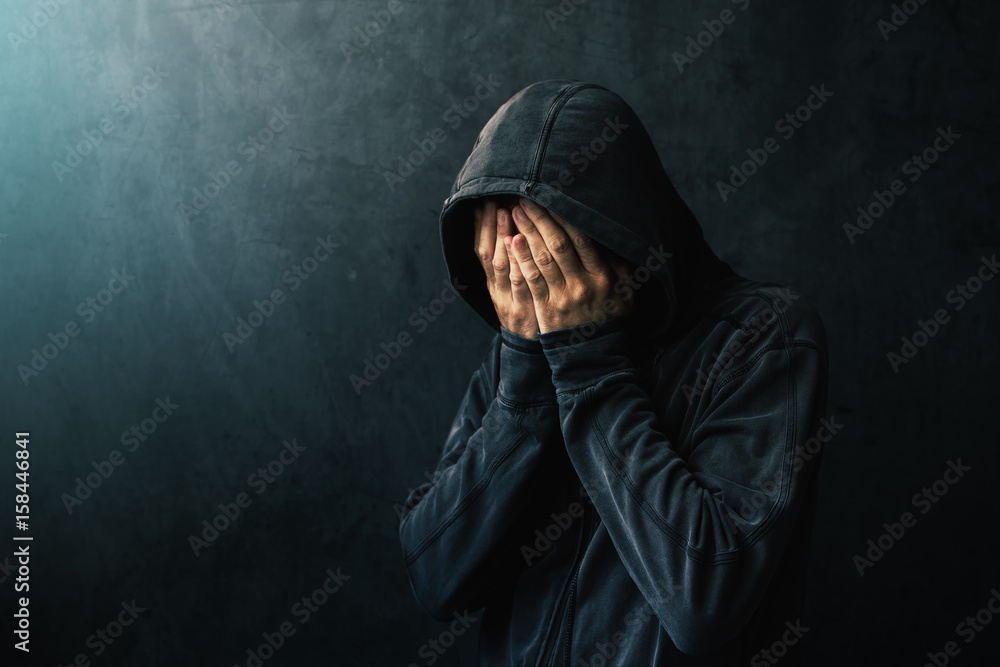 Wall mural desperate man in hooded jacket is crying - Wall murals