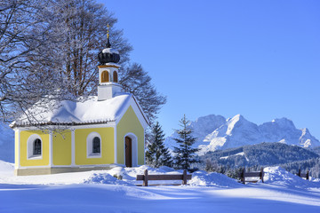 verschneite Kapelle mit Blick auf Zug- und Alpspitze