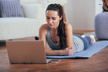 Fototapeta premium Beautiful young woman doing workout at home