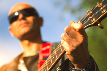 Acoustic guitar handle with hand making arrangement with the blur guitarist