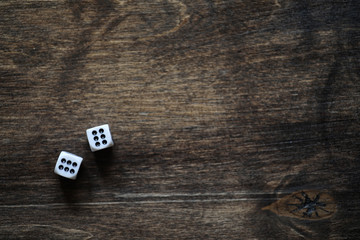 White dices on a brown wooden texture table