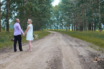 Fototapeta premium Just married lovers walking in a field in autumn day