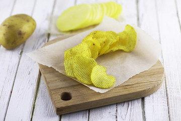 Potato chips on a wooden tray