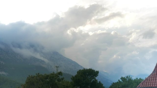 Timelapse clouds fly near the top of the mountains