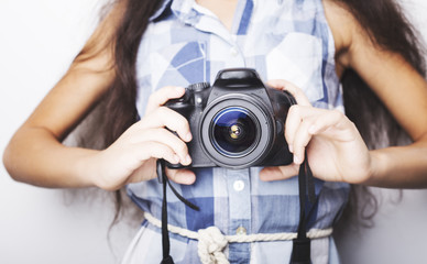 Fototapeta premium Cute brunette little girl holding an photo camera, isolated on white background