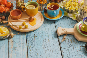 Cups with herbal tea and pieces of lemon, dried herbs and different decorations
