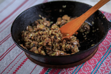 Fried mushrooms with onions on a frying pan on a plate