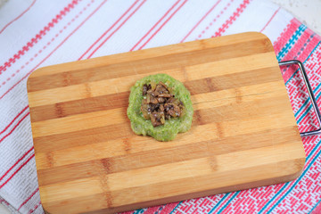 Crude forcemeat cutlet with a stuffing on a wooden board