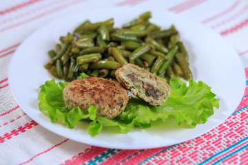 Cutlets with a stuffing with a garnish on a white plate on a light background