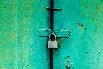 Padlock on the green metal door