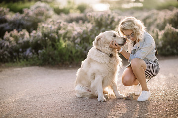Close-up portrait of rich man playing outdoor with her dog on the street,dog licks his master,girl hugging her puppy,golden labrador puppy,funny mood,positive emotions,kissing lips,walking alone,urban